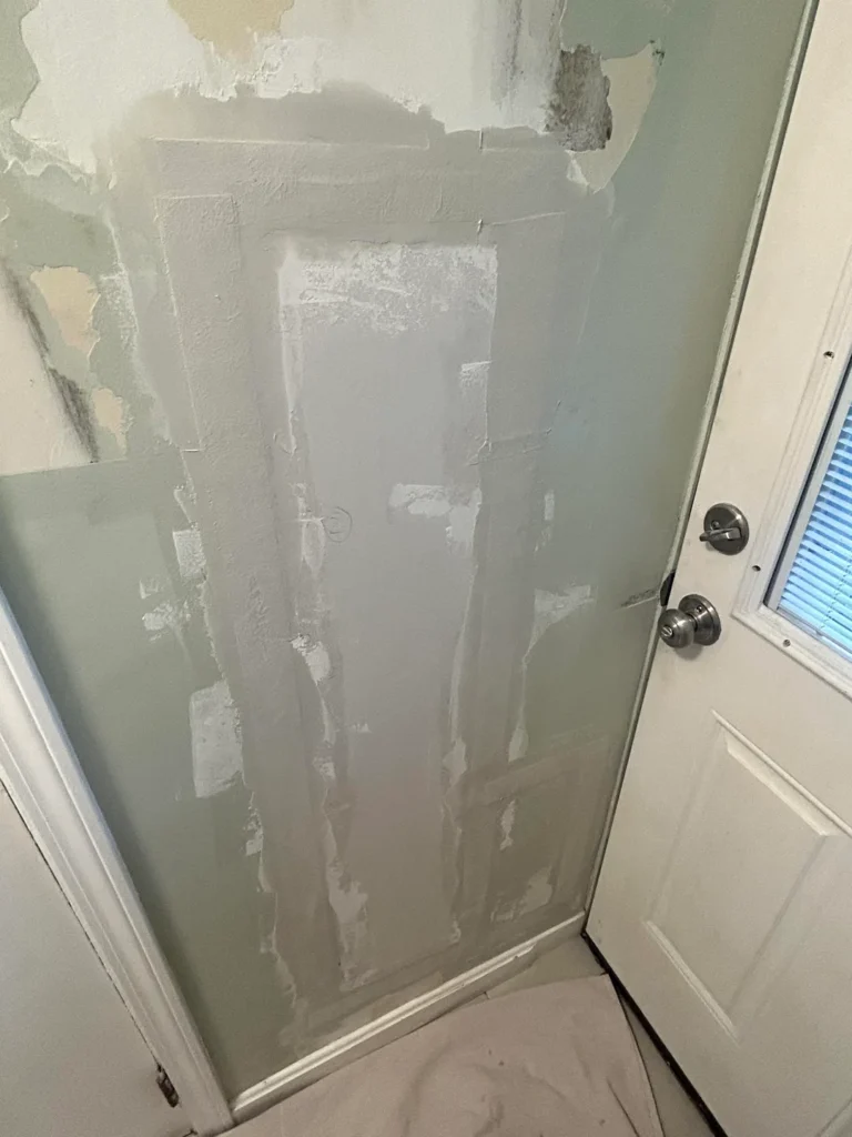 Drywall patch with joint compound applied over the repaired opening