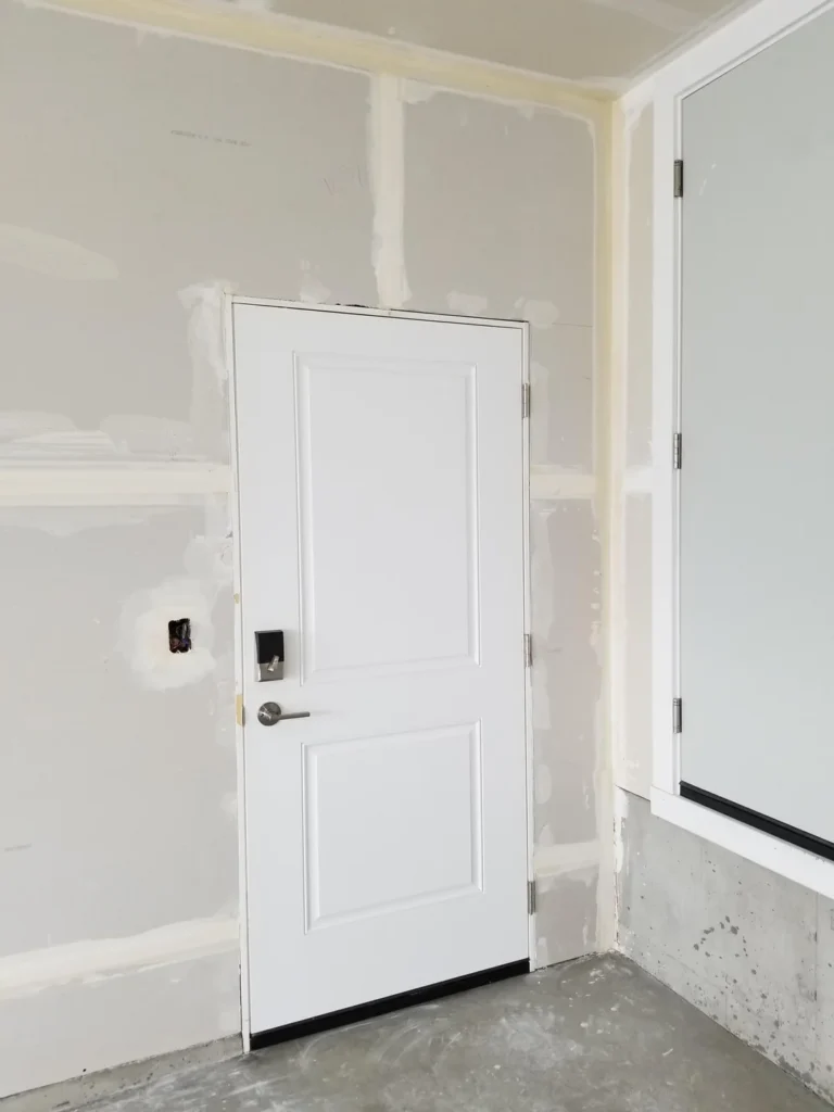 Garage drywall installation and finishing around an entry door