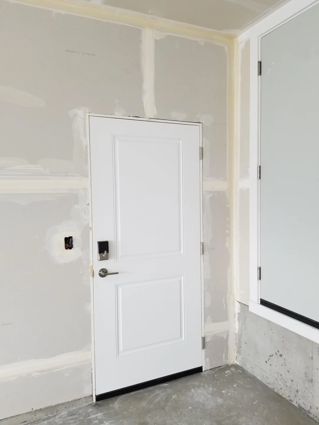 Garage drywall installation and finishing around an entry door