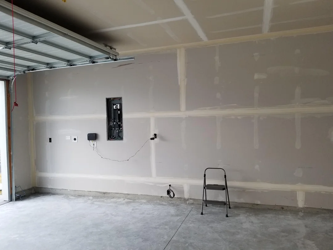 Garage wall after drywall installation, taping, and joint compound