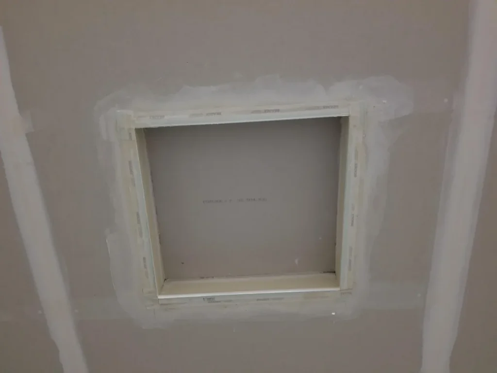 Small framed garage wall opening finished with drywall and joint compound