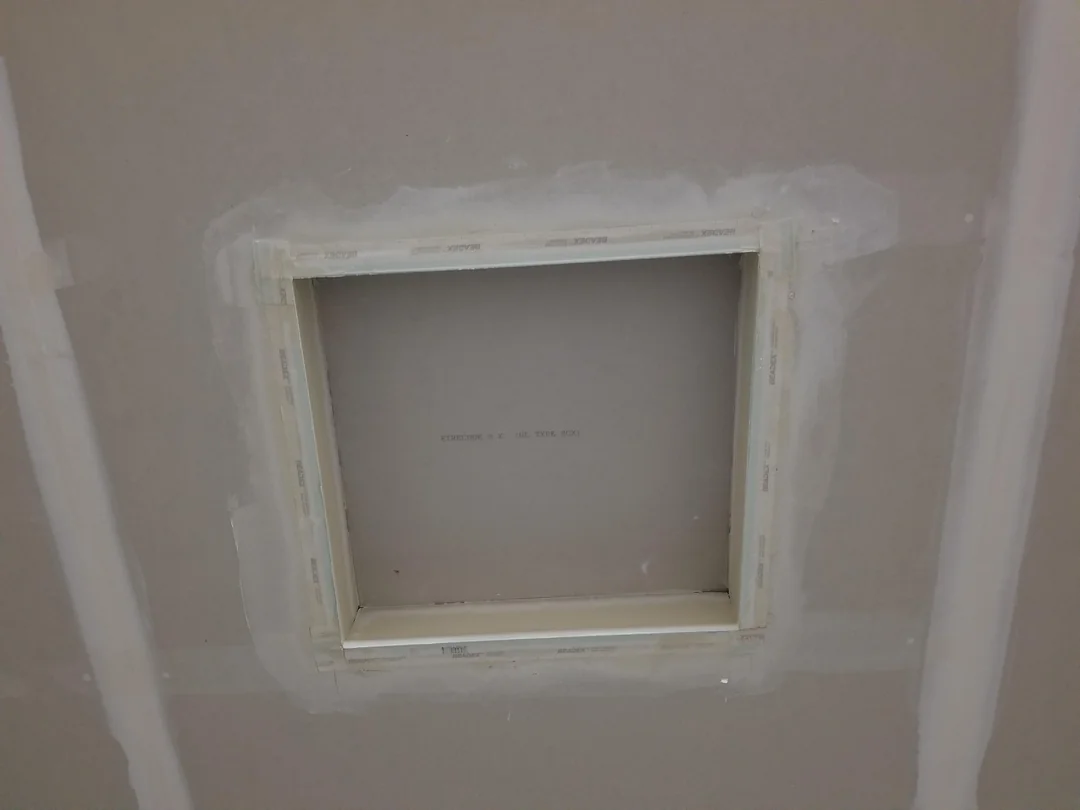 Small framed garage wall opening finished with drywall and joint compound