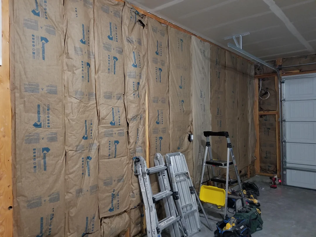 Garage wall insulation and tools before drywall installation