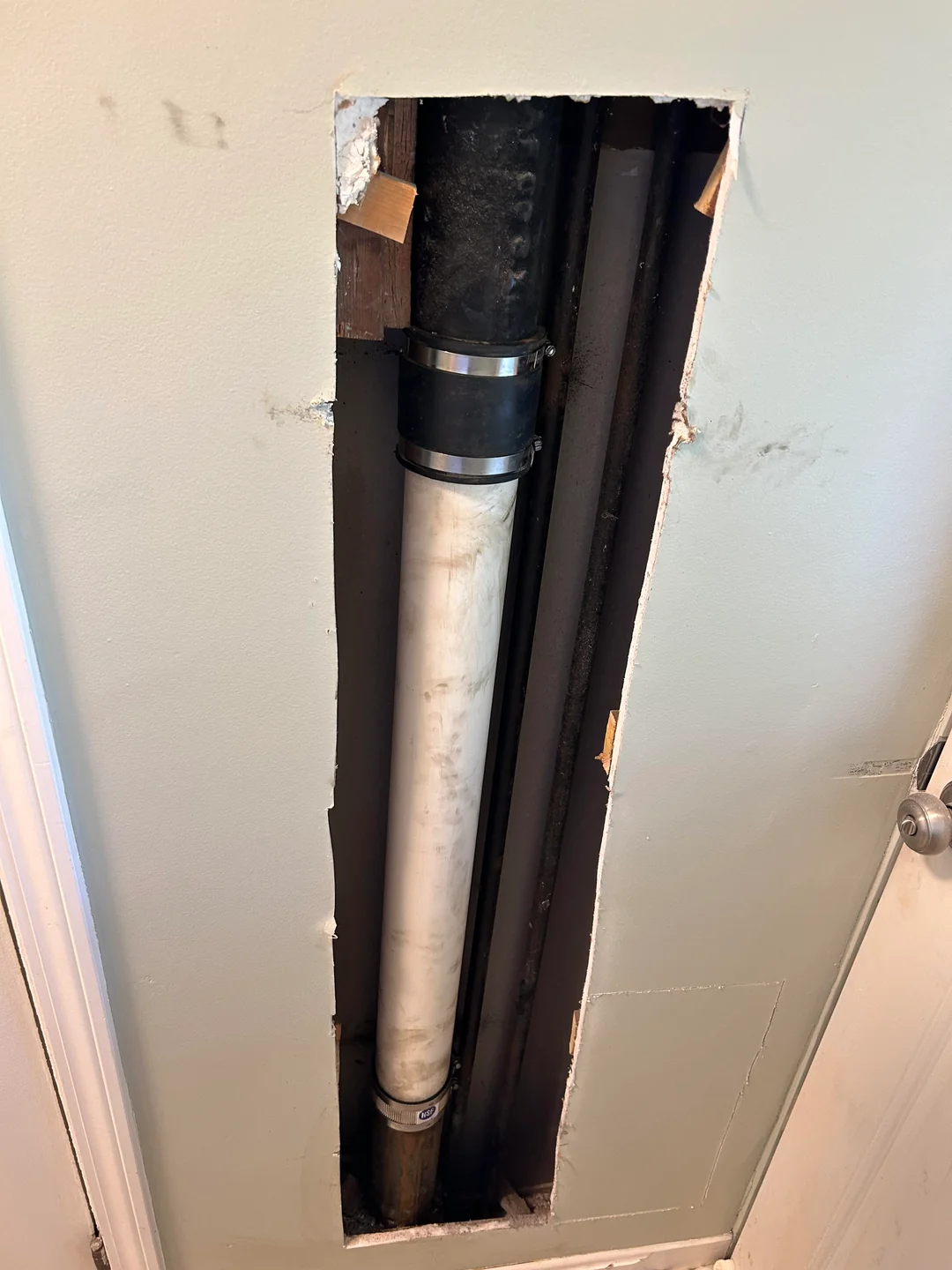 Wall opening exposing a vertical plumbing stack before drywall closure